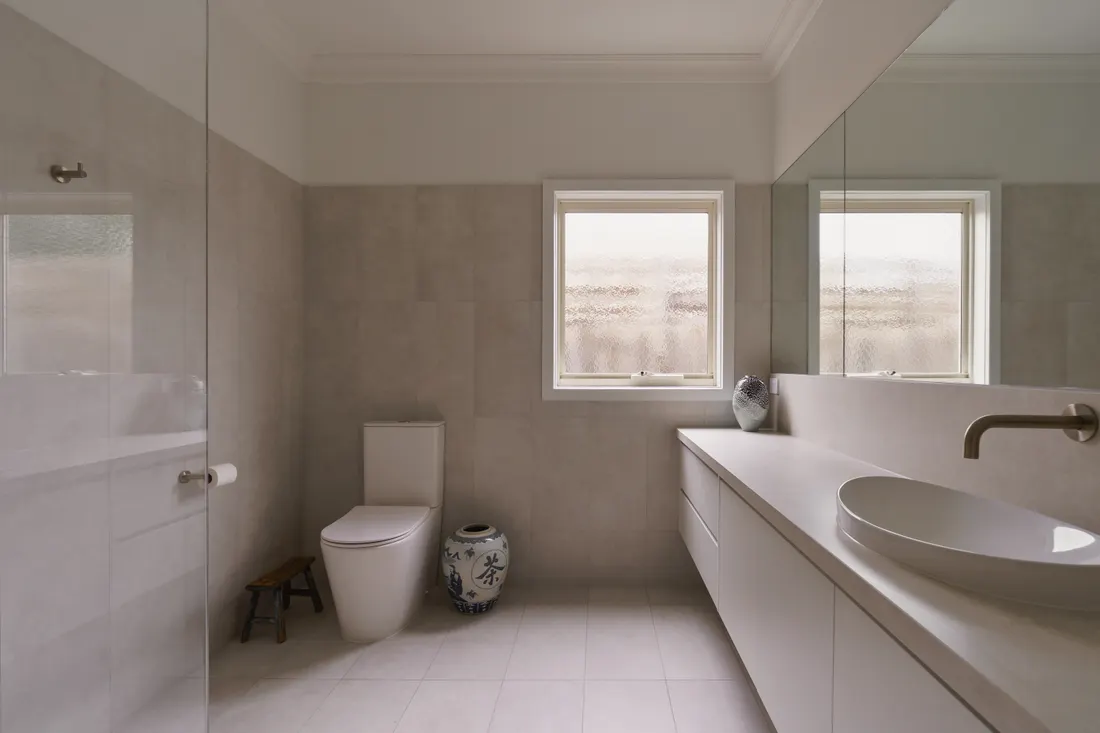 Bathroom with twin basins and window by MNA Builds