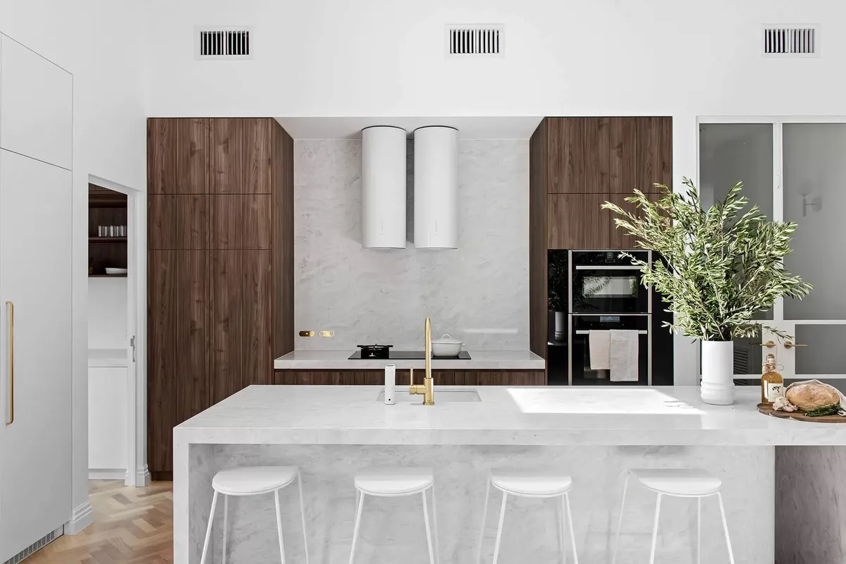 Open-plan kitchen with island bench and timber joinery by MNA Builds